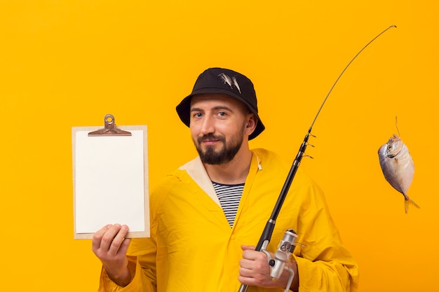 Free photo front view of fisherman holding fishing rod and notepad