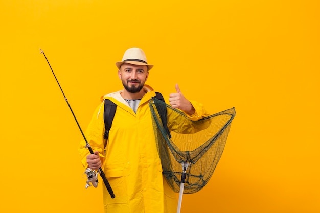 Free photo front view of fisherman holding net and giving thumbs up