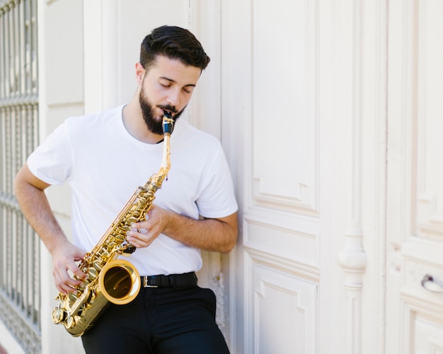 Free Photo front view focused man playing the sax