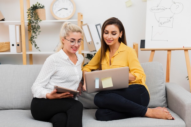 Front view formal dressed women looking on laptop