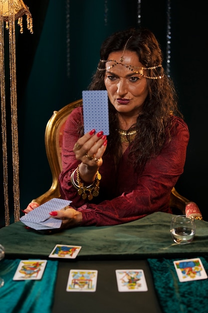 Free Photo front view fortune teller with tarot cards