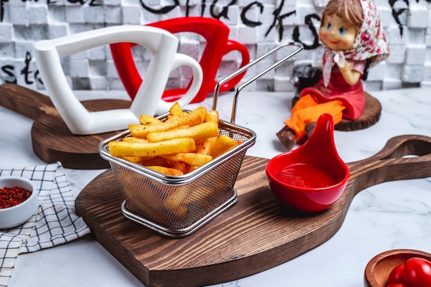 Free photo front view french fries in a basket with ketchup on the board