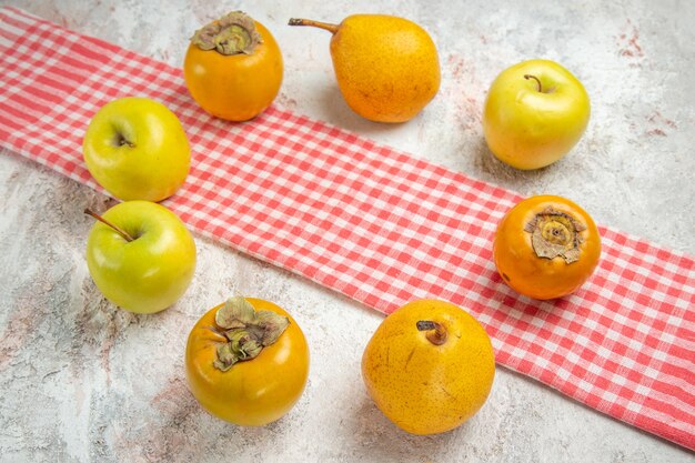 Front view fresh apples with persimmons on the white table fruit berry health