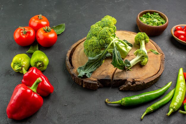 Front view fresh broccoli with tomatoes and bell-peppers on dark background