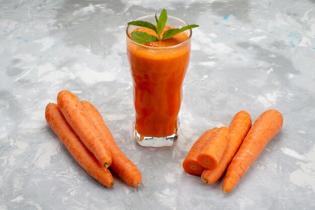 Front view fresh carrot juice inside long glass with leaf and along with fresh carrots vegetable health 