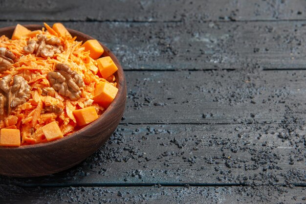 Front view fresh carrot salad grated salad with walnuts and garlic on dark desk diet salad health color nut