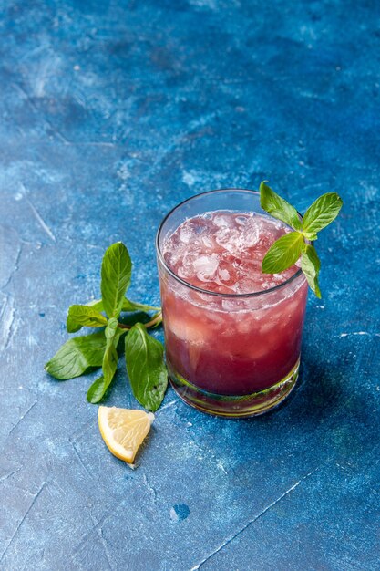 Front view fresh cool lemonade inside little glass with ice on a blue background cold juice drink color water fruit cocktail