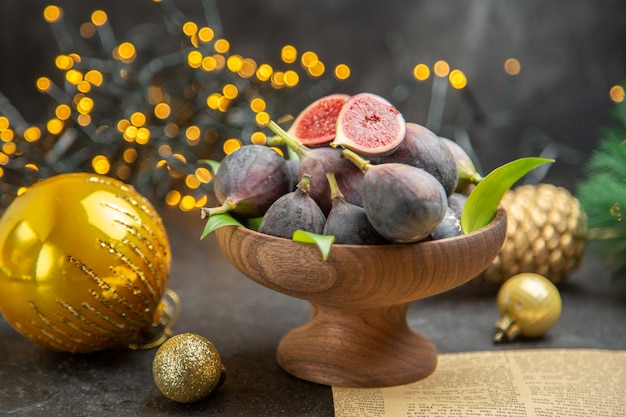 Free photo front view fresh figs around christmas toys on dark desk fruit dark taste xmas photo