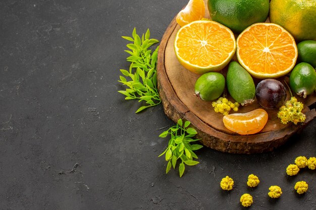 Front view fresh green tangerines with feijoas and candies on dark space