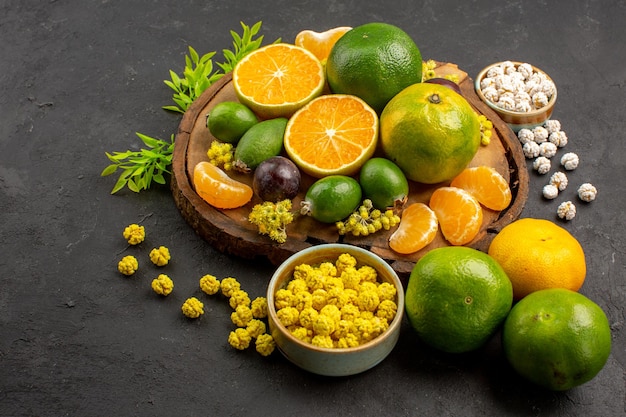 Free photo front view fresh green tangerines with feijoas and candies on dark space