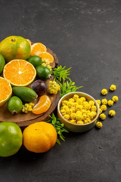 Front view fresh green tangerines with feijoas on dark desk citrus exotic fruit green fresh ripe