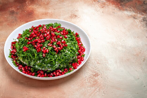 Front view fresh greens with peeled pomegranates on the light table fruit color green