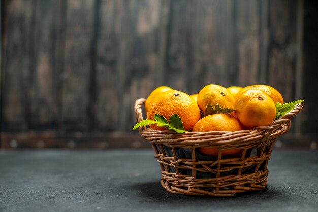 Front view fresh mandarines in wicker basket on dark free place