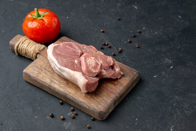 Front view fresh meat slice raw meat with tomato on dark background barbecue dish pepper kitchen food cow food salad animal meal