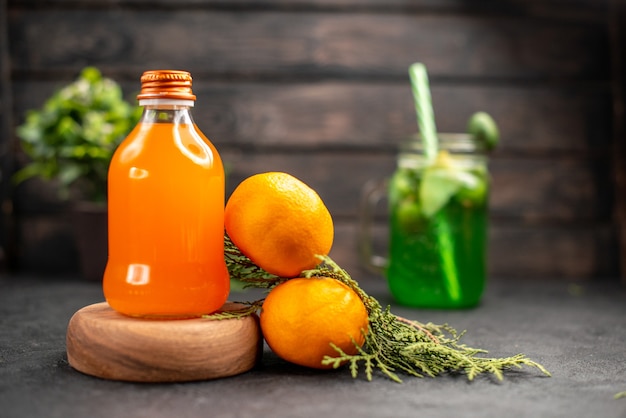 Front view fresh orange juice in bottle on wood board