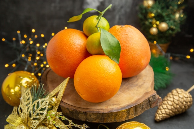 Front view fresh oranges around christmas toys on dark background fruit tropical exotic fresh juice