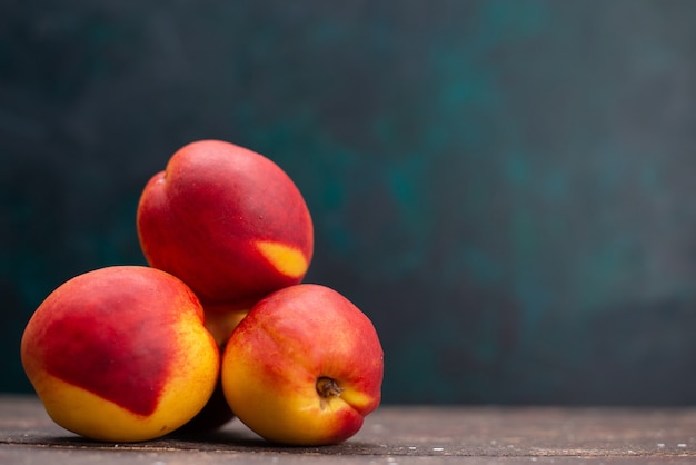 Free Photo front view fresh peaches delicious sweet fruits on dark-blue surface fruit juice mellow fresh summer