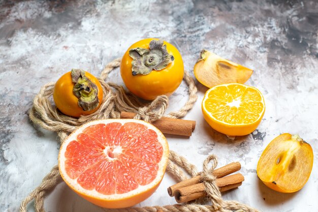 Front view fresh persimmons with grapefruit on the light table