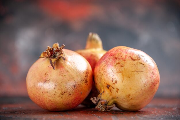 Front view fresh pomegranates on dark red isolated background