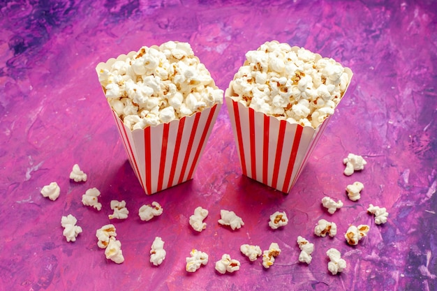 Front view fresh popcorn on a light pink table color cinema movie