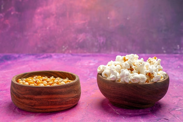 Free photo front view fresh popcorn with raw corns on pink table corn movie cinema color