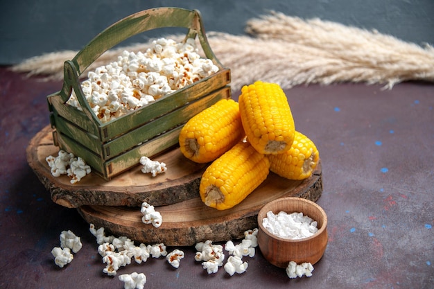 Front view fresh popcorn with yellow corns on a dark surface snack popcorn corn food