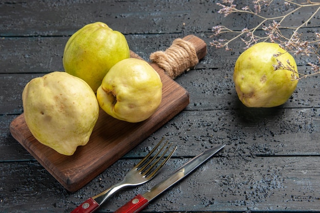 Front view fresh quinces mellow and sour fruits on dark-blue desk plant fresh sour fruit tree ripe