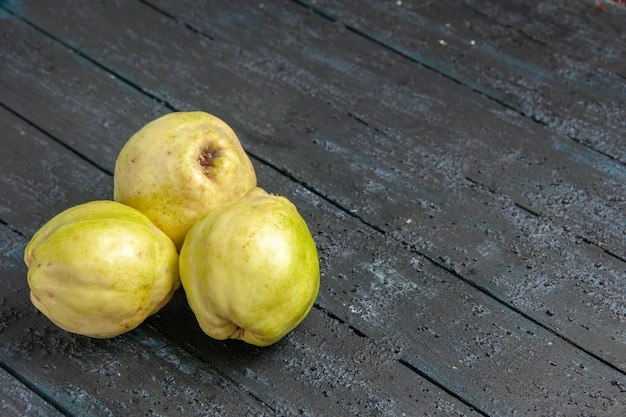 Free photo front view fresh quinces mellow and sour fruits on a dark-blue desk ripe fetus fresh tree sour plant fruit