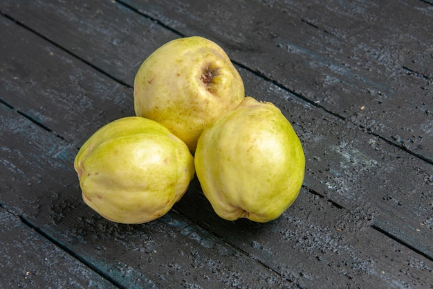 Free photo front view fresh quinces mellow and sour fruits on dark-blue desk ripe fetus fresh tree sour plant fruit