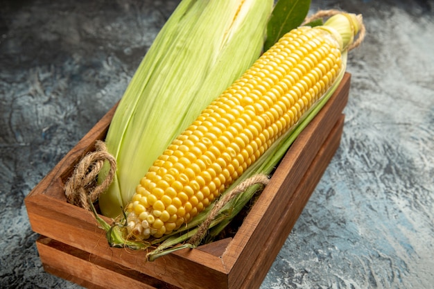 Free photo front view fresh raw corn yellow plant inside box on dark-light background