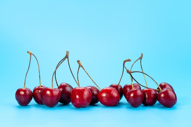 Free photo a front view fresh red cherries mellow and sour on blue, fruit summer color