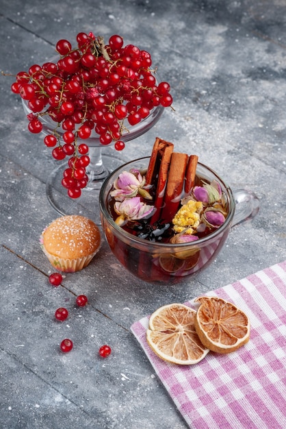 Front view fresh red cranberries with cup of tea cinnamon on the light desk fruit berry fresh coffee lemon