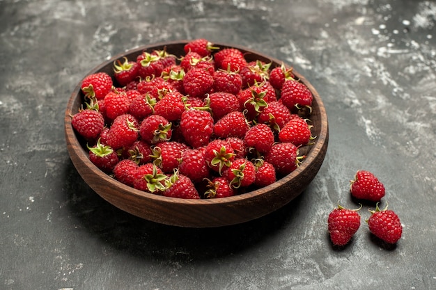 Front view fresh red raspberries inside plate on grey photo color wild berry fruit color cranberry