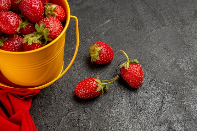 Front view fresh red strawberries inside little basket on dark background