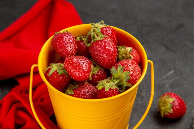 Front view fresh red strawberries inside little basket on the dark background