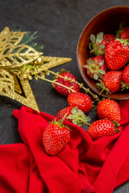 Front view fresh red strawberries inside plate with toy on the dark background color many fruit photo mellow