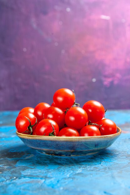 Front view fresh red tomatoes inside plate on blue table