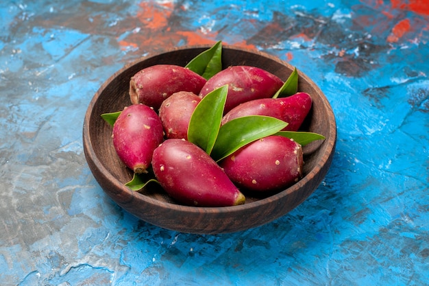 Front view fresh ripe plums inside wooden plate on the blue background color tree sour fruit  mellow