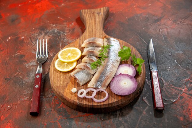 Front view fresh sliced fish with onion rings and lemon on a dark snack meal color meat seafood photo