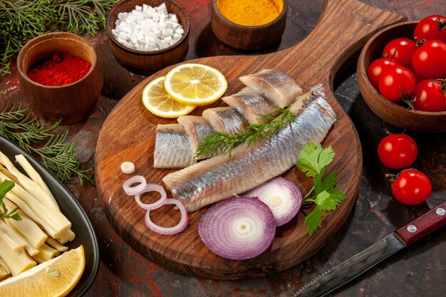 Front view fresh sliced fish with seasonings and onion rings on dark seafood color photo snack meat ripe salad