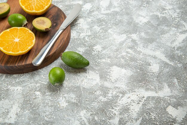 Front view fresh sliced oranges with feijoa on the white background ripe fruit exotic tropical fresh