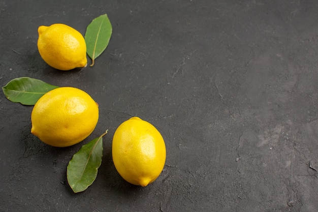 Front view fresh sour lemons lined on dark background