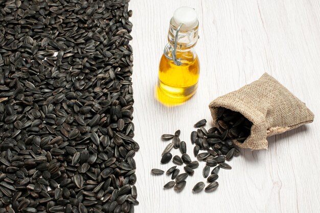 Front view fresh sunflower seeds black colored seeds on white desk seed snack photo many oil