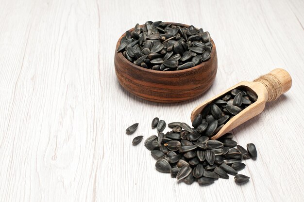 Front view fresh sunflower seeds black seeds on white desk photo snack many seed oil