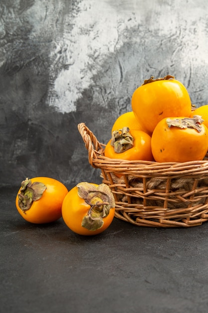 Free photo front view fresh sweet persimmons inside basket on the dark table