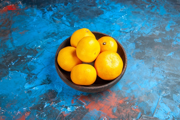 Front view fresh tangerines inside plate on a blue table