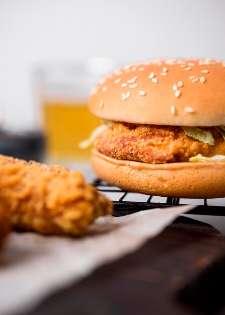 Front view fried chicken pieces and burger on tray