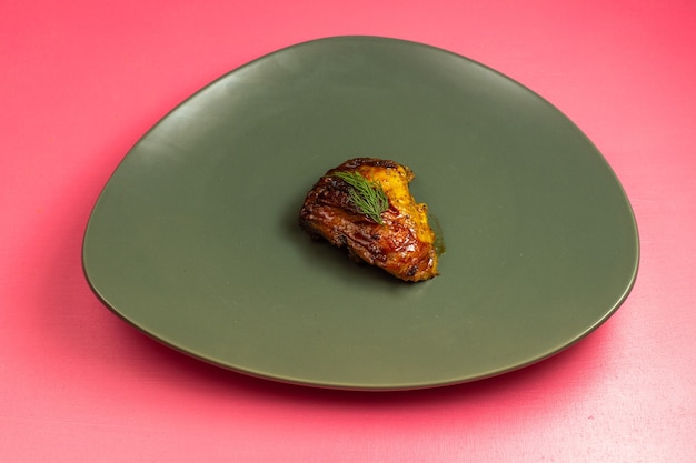 Free photo front view of fried meat slice inside green plate on pink wall