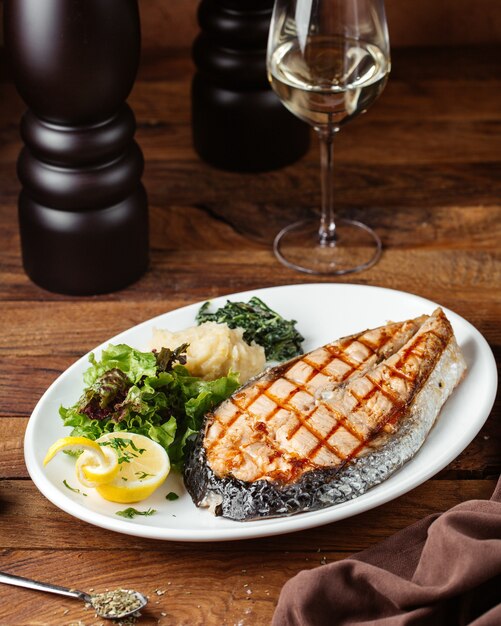 A front view fried meat slice with lemon and greens on the brown desk meal food meat