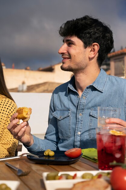 Front view friends eating outdoors